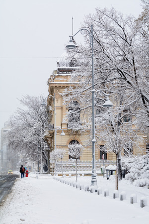 Bucharest, Romania - January 17: Calea Victoriei Street on January 17, 2016 in Bucharest, Romania. Bucharest downtown after massive snowing, Calea Victoriei and city center neighborhood, man and child walking.のeditorial素材