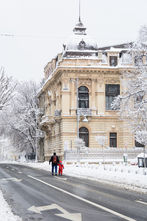 Bucharest, Romania - January 17: Calea Victoriei Street on January 17, 2016 in Bucharest, Romania. Bucharest downtown after massive snowing, Calea Victoriei, city center neighborhood, man and child walking.のeditorial素材