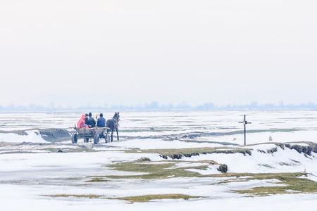 Calugareni, Romania - January 17: Calugareni on January 17, 2016 in Calugareni Giurgiu.  Horizontal winter view of men on cart with horse.のeditorial素材