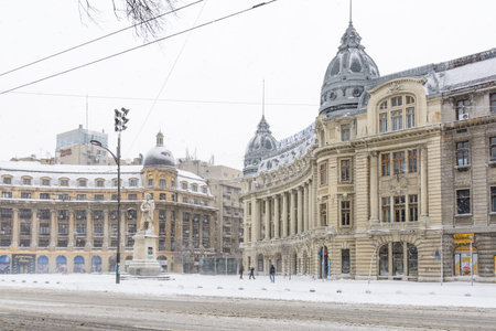 Bucharest, Romania - January 17: University Square on January 17, 2016 in Bucharest, Romania. Bucharest downtown after massive snowing, University Square, city center neighborhood, few people, statue and street covered with snow.のeditorial素材