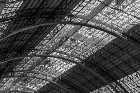 Metal construction abstract background. Structure of steel roof frame for construction in black and white.の写真素材