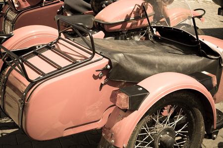 Closeup with retro motorcycle. Vertical background with part of beautiful pink old motorcycle.の写真素材