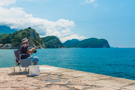 The fisherman is fishing from a pierの写真素材