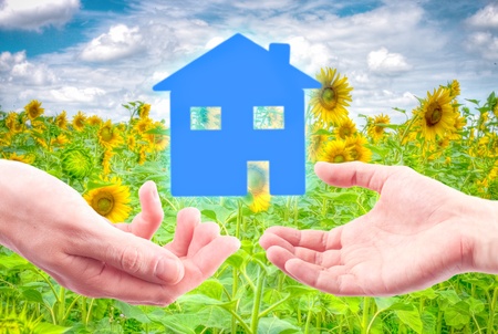 From hand to hand the house as a symbol of real estate business.の写真素材