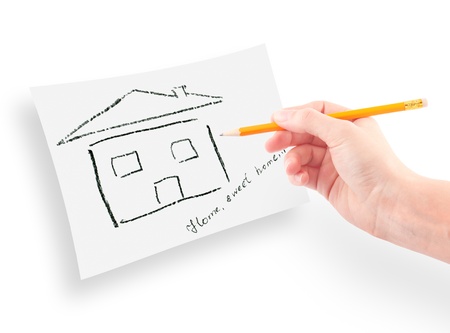 woman's hand with the pencil drawing the dream home on a white sheet of paper.の写真素材