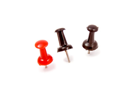 Different color drawing-pins on white background