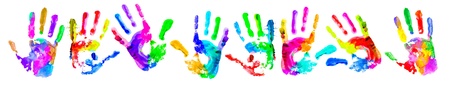 Multi coloured painted handprints arranged in a circle on a white background.の写真素材