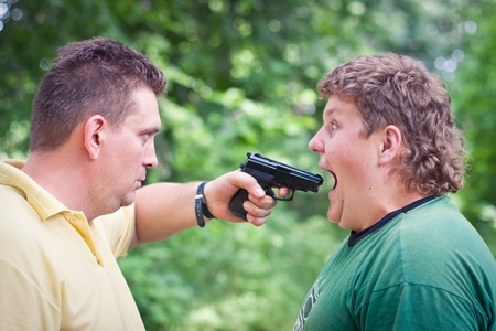 Man with a gun taking aim at anotherの写真素材