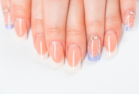 Beautiful female hands with french manicure on a light background with a shadowの写真素材