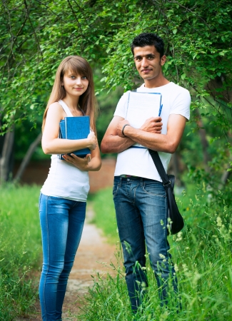 Two students guy and girl studying in park with book outdoorsの写真素材
