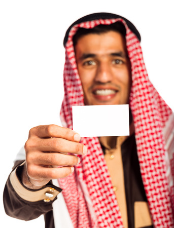 Young smiling arab showing business card in hand isolated on white backgroundの写真素材