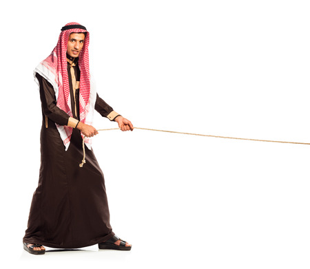 Young Arab pulling a rope isolated on white backgroundの写真素材