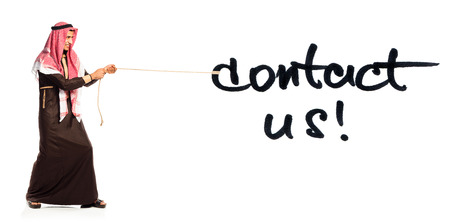 Young Arab pulling a rope with inscription Contact Us isolated on white backgroundの写真素材