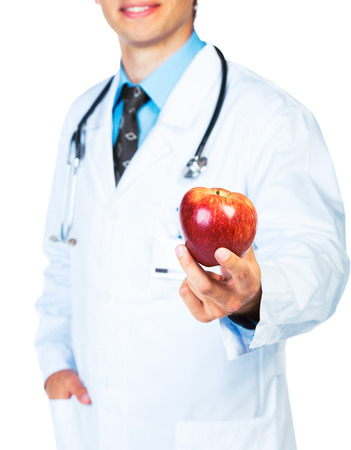 Smiling doctor holding red apple on white close-upの写真素材