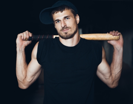 Muscular man with baseball bat on the ruinsの写真素材