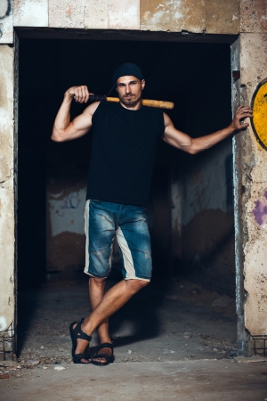 Muscular man with baseball bat on the ruinsの写真素材
