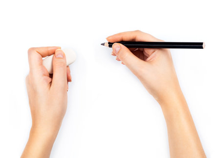 Human hands with pencil and erase rubber writting something. On white background
