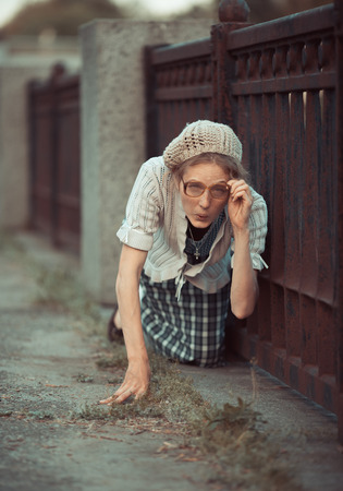Funny girl with glasses and a vintage dress outdoorsの写真素材