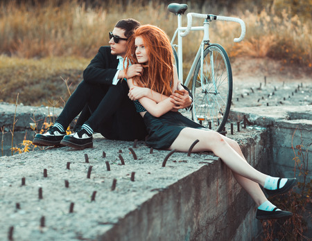 Young stylish couple - the guy with the girl and bicycle outdoorsの写真素材