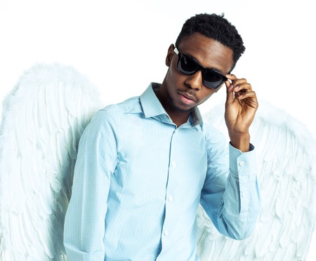 African American young man with angel wings in sunglassesの写真素材