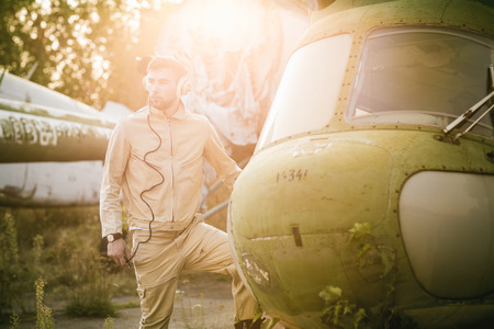 Young serious pilot posing near the helicopterの写真素材