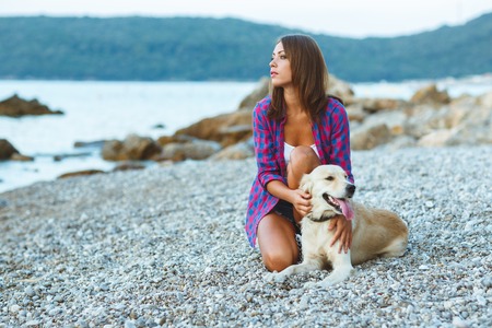 woman with a dog on a walk on the beachの写真素材