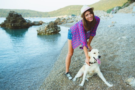 woman with a dog on a walk on the beachの写真素材