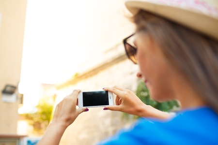 Girl in hat making photos of a church by the smartphone, Montenegro, Balkansの写真素材