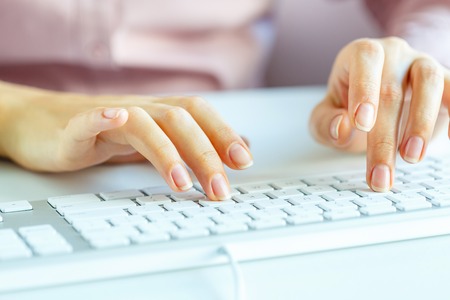 Female hands or woman office worker typing on the keyboardの写真素材