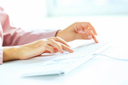 Female hands or woman office worker typing on the keyboardの写真素材