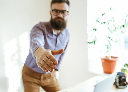 Beard business man with arm extended to handshakeの写真素材