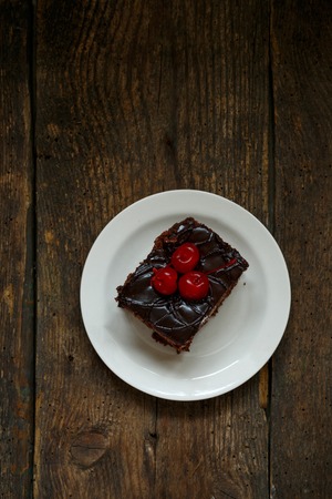 Delicious chocolate cakes with cherry close-up on wooden backgroundの写真素材