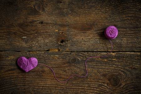 Purple Heart with a ball of thread on on old shabby wooden background. Image of Valentines day