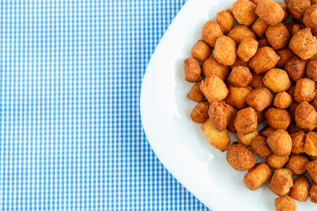 Golden cookies on a white plate and blue checkered tableclothsの写真素材