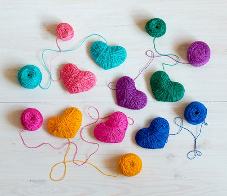 Multicolored Hearts with a balls of thread on white wooden background. Image of Valentines dayの写真素材