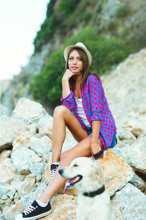 Summer vacation - woman with a dog on a walk on the beachの写真素材