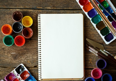 Art of Painting. Painting set: paper, brushes, paints, crayons, watercolor, acrylic paint on a wooden backgroundの写真素材