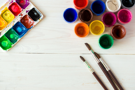 Art of Painting. Painting set: brushes, paints, watercolor, acrylic paint on a white wooden background top down viewの写真素材