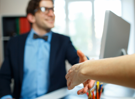 Modern young business man with arm extended to handshakeの写真素材