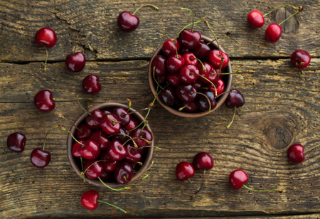 Ripe cherries in a clay bowl on a shabby wooden background