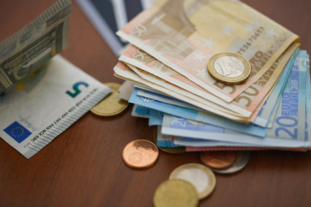 Money euro coins, banknotes and credit cards on wooden background