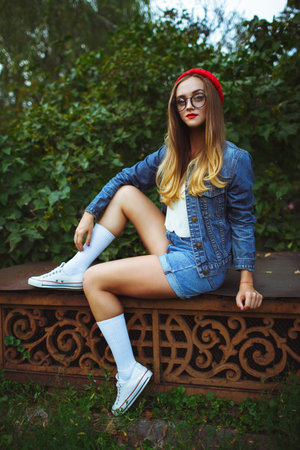 Beautiful young girl posing against the backdrop of the green grass and treesの写真素材