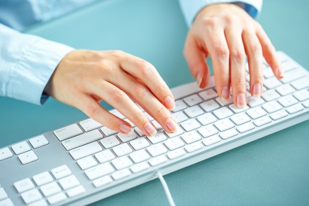 Female hands or woman office worker typing on the keyboardの写真素材