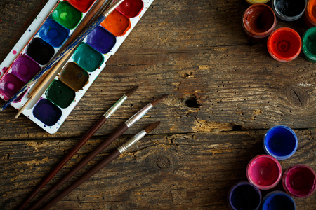 Art of Painting. Painting set: brushes, paints, crayons, watercolor, acrylic paint on a wooden backgroundの写真素材
