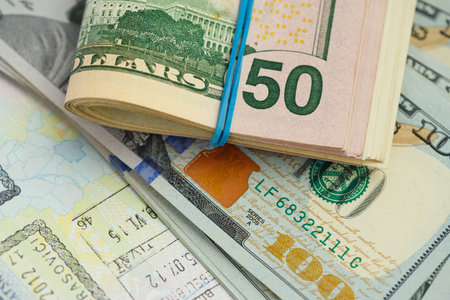 American money is on the top of the opened passport - travel concept