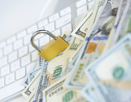 Security lock on dollar bills with white computer keyboard - breach of security online payments conceptの写真素材