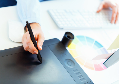 Female artist drawing something on graphic tablet at the home officeの写真素材
