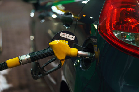 Car refueling on a petrol station in winter at night closeup