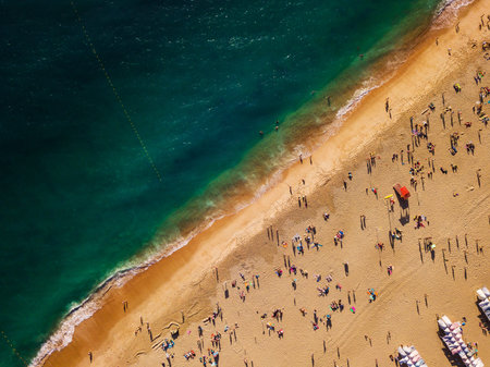 View from above to a busy beach. The Portuguese coast of the Atlantic Oceanの写真素材