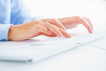 Female hands or woman office worker typing on the keyboardの写真素材